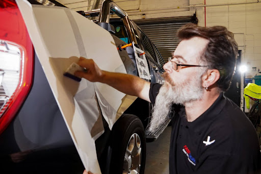 fastsigns employee applying a vehicle wrap